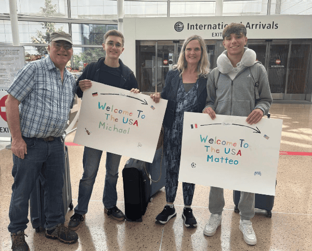 Family Welcoming International Students At Airport