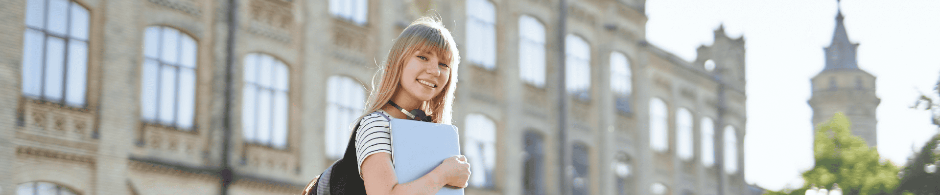 Female Student Smiling Outside University Building
