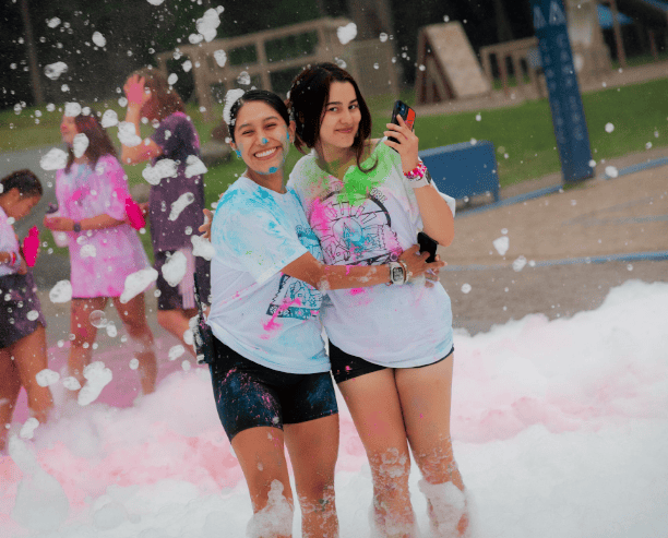 Friends Hugging At Foam Color Party