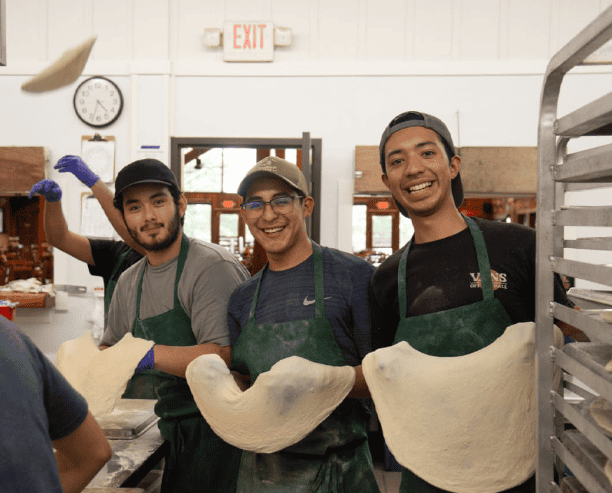 Friends Tossing Dough In Bakery Kitchen