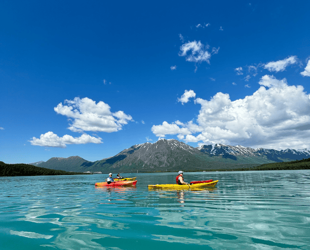 Kayakers Exploring Glacial Lake Under Blue Sky