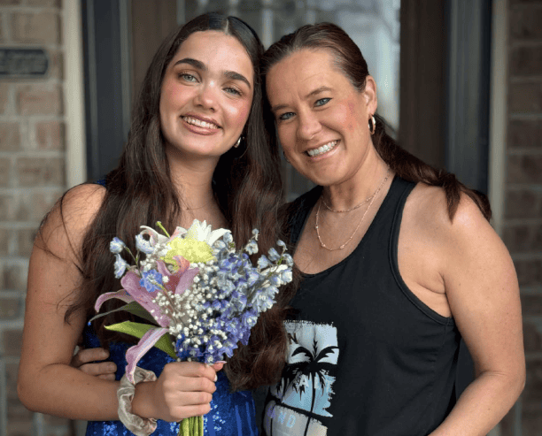 Mother And Daughter Smiling With Flower Bouquet