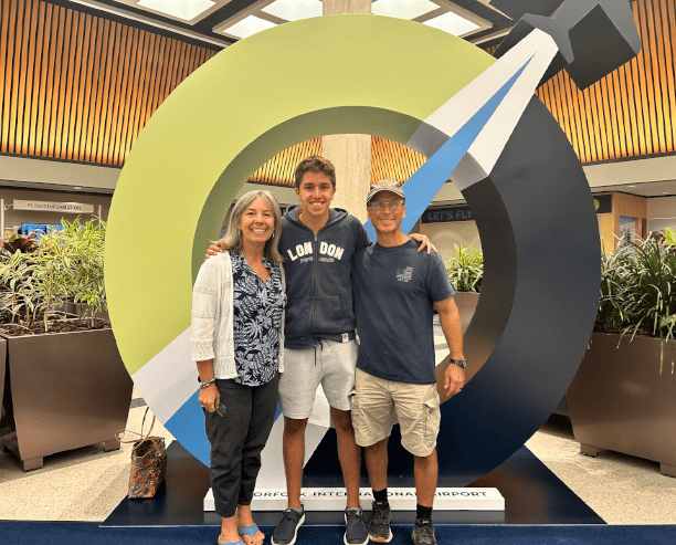 Parents With Student At Airport Display