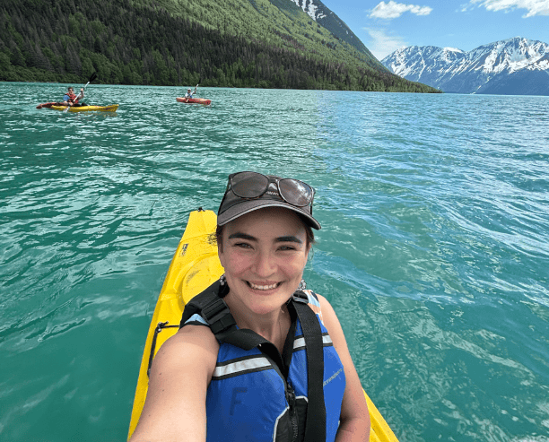 Woman Kayaking On Turquoise Lake In Mountains