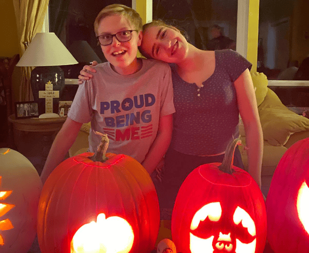 Siblings Smiling With Jack O Lanterns On Halloween